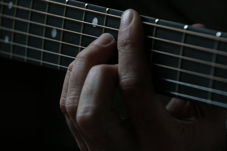 fingers on a guitar fretboard