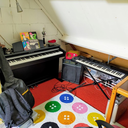 Photo of Roland XP-10 and more gear in a studio, amplifier, and synths