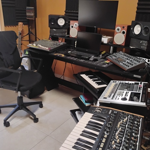 Photo of Alesis Q25 Keyboard Controller and more gear in a studio, synths, and DAW