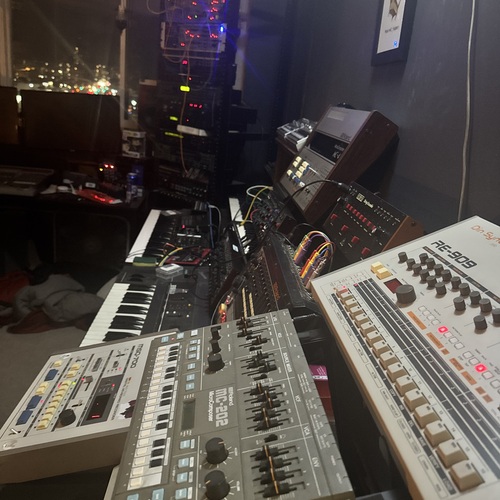 Photo of Roland MC-4 MicroComposer and more gear in a studio, synths, drum machine, and signal chain